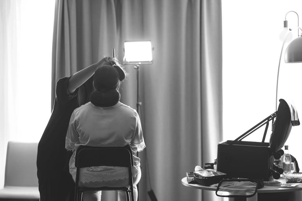 A bride getting her hair styled by a professional before the wedding ceremony.